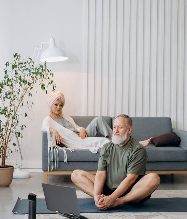 Person performing a gentle stretching exercise in a calm, minimalist room.